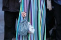 Woman with colorful striped coat and bag with small bear before N 21 fashion show, Milan Fashion Week street