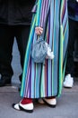 Woman with colorful striped coat and bag with small bear before N 21 fashion show, Milan Fashion Week street