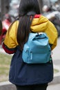Woman with light blue Hunter backpack and yellow and blue jacket before Giorgio Armani fashion show, Milan