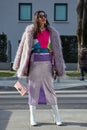 Woman with violet purple fur coat and skirt before Emporio Armani fashion show, Milan Fashion Week street
