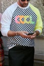 Man with black and white checkered sweater with cool writing before Prada fashion show, Milan Fashion Week street