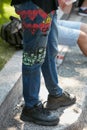 Man with blue printed Vivienne Westwood jeans and black Nike sneakers before Giorgio Armani fashion show, Milan