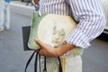 Man with Givenchy bag with woman face design and striped white purple shirt before Les Hommes fashion show, Milan