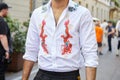 Man with white shirt with orange dragons and floral decorations before Versace fashion show, Milan Fashion Week