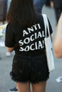 Woman with black shirt with Anti Social white writing before Fendi fashion show, Milan Fashion Week street style