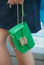 Woman with green leather Furla bag with golden chain before Emporio Armani fashion show, Milan Fashion Week