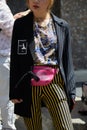 Woman with pink Gucci pouch and black and yellow striped trousers before Marni fashion show, Milan Fashion Week