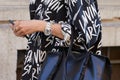 Woman with Rolex watch and black and white Lanvin jacket before Prada fashion show, Milan Fashion Week street