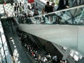 Groups of business people at the Milan fair. Escalators and moving belts. Modern architecture in glass and steel