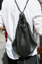 Man with black leather backpack and white shirt before Blumarine fashion show, Milan Fashion Week street