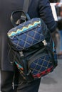 Man with Prada backpack in black, blue, yellow and red colors before Prada fashion show, Milan Fashion Week