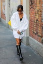 Milan, September 24, 2020: model is wearing a white cardigan and a pair of shiny black boots