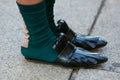 Woman with black leather slippers and green socks before Max Mara fashion show, Milan Fashion Week street