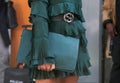 Woman with dark green dress and bag and Gucci belt before Giorgio Armani fashion show, Milan Fashion Week