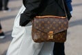 Woman with Louis Vuitton bag with black jacket and gray trousers before Gabriele Colangelo fashion show,