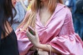 Woman with pink silk shirt and smartphone in hand before Marco de Vincenzo fashion show, Milan Fashion Week