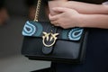 Woman with Pinko black leather bag before Giorgio Armani fashion show, Milan Fashion Week street style on