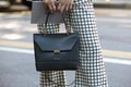 Woman poses for photographers before Fendi show with Coccinelle bag during Milan Fashion Week Day 2, Spring