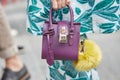 Woman with purple Patrizia Pepe bag before Giorgio Armani fashion show, Milan Fashion Week street style on