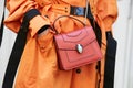 Woman with red Bulgari bag and orange trench coat before Fendi fashion show, Milan Fashion Week street style