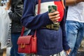 Woman with red Saint Laurent leather bag and smartphone cover with palm tree leaves before Antonio Marras Royalty Free Stock Photo