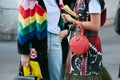 Women with colorful fur coat and red bag before Prada fashion show, Milan Fashion Week street style on