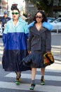 Women with gray and blue clothings and green shoes walking before Prada fashion show, Milan Fashion Week