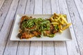 Milanesa a la Napolitana with melted cheese, roasted tomatoes, arugula,