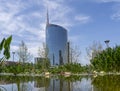 Milano, Italy. The iconic Unicredit tower and the BAM public park. In the foreground the pond with the water lilies in bloom Royalty Free Stock Photo