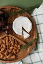 Mildewed cheese, nuts and grapes. A tasty and healthy dish on a green background. View from above
