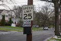 A 25 mile per hour speed limit sign on a wooden utility pole on the side of a community street Royalty Free Stock Photo