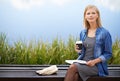 Miles away from the office. an attractive blonde woman reading a book during her lunch break on a park bench. Royalty Free Stock Photo