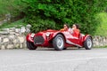 1000 Miles 2019, Brescia - Italy. May 14, 2019: The historic Mille Miglia car race. Two girls rushing in a beautiful red vintage