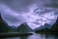 Milford Sound and Mitre Peak, South Island, New Zealand. Steep sided mountains rise from calm waters of the fiord with moody sky Royalty Free Stock Photo