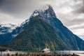 Milford Sound and Mitre Peak, South Island, New Zealand. Steep sided mountains rise from calm waters of the fiord with moody sky Royalty Free Stock Photo