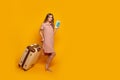 Miling woman traveler holding passport with ticket and credit card. yellow wall Royalty Free Stock Photo