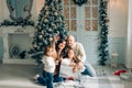 Miling young family in Christmas atmosphere making photo with smartphone Royalty Free Stock Photo