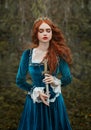 militant fantasy red-haired woman queen holding dagger in hands. Girl warlike princess warrior with sharp blade knife