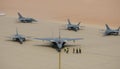 Military airbase with several parked jets, ground crew preparing for flight, desert backdrop and dust particles 2 Royalty Free Stock Photo