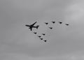 Military airplanes flying in V formation with grey and cloudy day at background