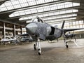 Military aviation arsenal inside a military hangar awaiting deployment. F 35 Fighter jet, stealth fighter and attack drone.