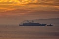 Military Battleship using tugs go to the port Royalty Free Stock Photo