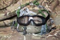 Military camouflage protective helmet and anti-fog protective tactical glasses on a camouflage background, military