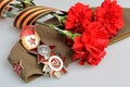 Military cap, red flowers, Saint George ribbon, orders of Great Patriotic war Royalty Free Stock Photo