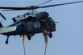 Military combat and war with helicopter flying into the chaos and destruction. Close up of Soliders leaving chopper on rope.
