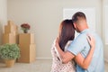 Military Couple Facing Empty Room with Packed Moving and Potted