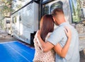 Young Couple Looking At A Beautiful RV At The Campground.