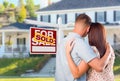 Military Couple Looking At House with Sold For Sale Realty Sign Royalty Free Stock Photo