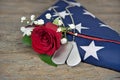 Military dog tags and rose on folded flag