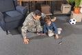 military father and son playing with toys while sitting on floor Royalty Free Stock Photo